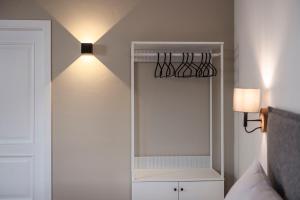 a bedroom with a mirror and a light on the wall at Brixen City Maisonette in Bressanone +11 photos