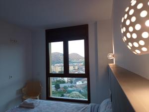 a bedroom with a large window with a view at Allotjament Buixeda in Olot