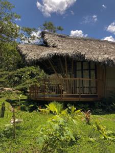 una casa con techo de paja y terraza en Bosque Guardian Lodge en Tarapoto