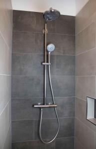 a shower with a shower head in a bathroom at Landapartments Smitmans in Kerken