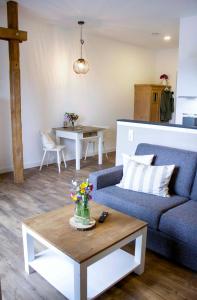 a living room with a blue couch and a table at Landapartments Smitmans in Kerken