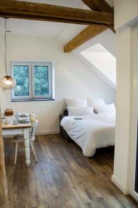 a bedroom with a bed and a desk and a window at Landapartments Smitmans in Kerken