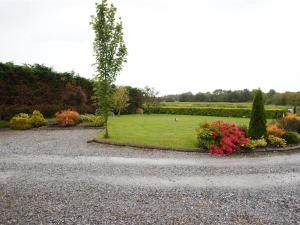 a garden with a field of grass and flowers at Dun Cromain B&B in Banagher