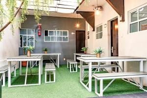 a patio with tables and benches in a building at Ayenda La Selva in Mexico City