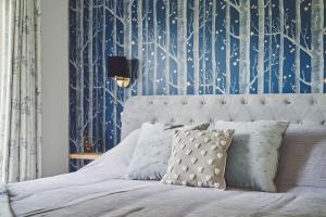 a bedroom with a bed with a blue and white wallpaper at Shepherds Rest in Llandyssil