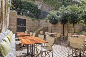 un restaurante con mesas de madera y sillas en una terraza en Pur Oporto Boutique Hotel by actahotels, en Oporto