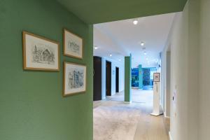 un couloir avec des murs verts et des photos sur le mur dans l'établissement Gästehaus Sonnenhof, à Cassel