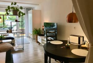 - un salon avec une table et une salle à manger dans l'établissement 'Das kleine Feine' - Ruhige, helle Ferienwohnung mit Parkplatz und Balkon, à Pforzheim