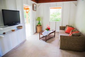a living room with a flat screen tv on a wall at Maison avec vue sur mer à Saint-François, confortable et équipée in Saint-François