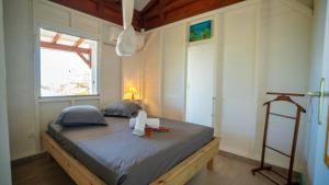 a bedroom with a large bed with a window at Maison avec vue sur mer à Saint-François, confortable et équipée in Saint-François
