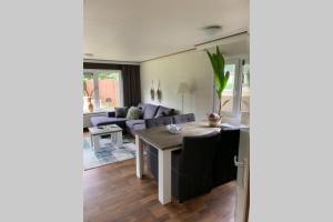 een woonkamer met een bank en een tafel bij Ruim chalet op de Veluwe in Beekbergen op recreatiepark Topparken met vrije tuin en eigen parkeerplaats in Beekbergen