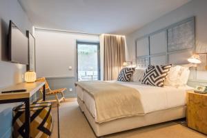 um quarto com uma cama, uma secretária e uma janela em Pur Oporto Boutique Hotel by actahotels no Porto