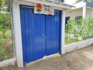 a blue garage door with a sign on it at Hotel Puerta Azúl Capurganá in Capurganá