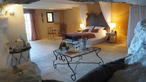 a bedroom with a bed and a table in a room at Le Clos Saint Saourde in Beaumes-de-Venise