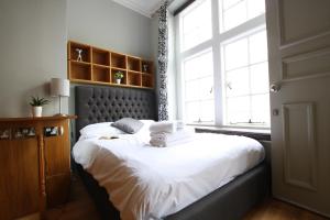 a bedroom with a large bed with a large window at Historic two bed apartment in Heart of the City in Bristol