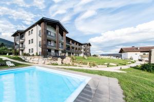 a resort with a swimming pool in front of a building at Chalet Kristall - Dolomites Garden Chalet in Falzes