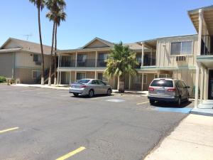 two cars parked in a parking lot in front of a building at Value Inn & Suites in El Centro