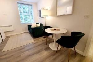 uma sala de estar com uma mesa e cadeiras e um sofá em Town Centre 1 Bed, Close to the Beach with Parking em Bournemouth