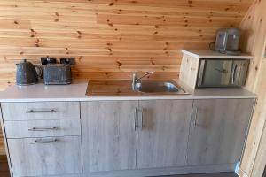 a kitchen with a sink and a microwave at Allt Yelkie Pod Dha, Earlish in Earlish