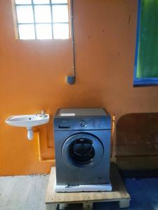 - un lave-linge dans la salle de bains pourvue d'un lavabo dans l'établissement Ti kaz a Annick, à Bouillante