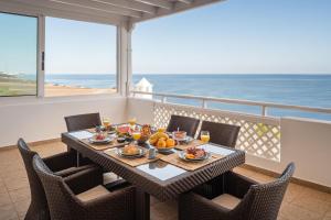 einen Tisch mit Speisen auf einem Balkon mit Meerblick in der Unterkunft ODIN LUXURY VILLA by Buenavilla in Puerto Calero