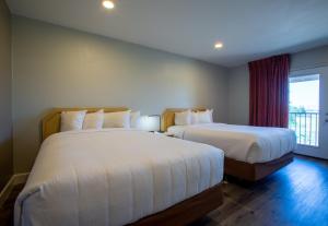 2 camas en una habitación de hotel con ventana en Hotel Elev8 Flagstaff I-40 Exit 198 Butler Ave, en Flagstaff