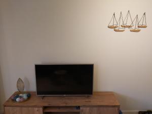 Une télévision à écran plat est installée au-dessus d'une table en bois. dans l'établissement Melrose 0301, à Middelkerke