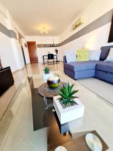 a living room with a blue couch and a table at Stunning apartment C106 with balcony looking over pool in Peyia