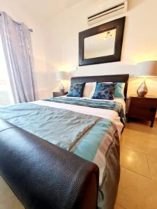 a bedroom with a large bed with a mirror on the wall at Stunning apartment C106 with balcony looking over pool in Peyia +32 photos