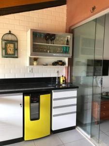 a kitchen with a black and yellow counter and a refrigerator at FLAT WINTERVILLE GRAVATA in Gravatá