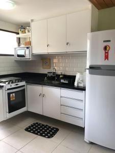 a kitchen with white cabinets and a white refrigerator at FLAT WINTERVILLE GRAVATA in Gravatá