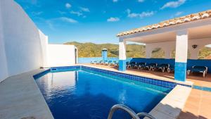 a villa with a swimming pool and a patio at Casa Alejandro Almachar by Ruralidays in Almáchar