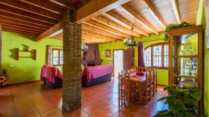a living room with green walls and a table and chairs at Casa Poniente Almachar by Ruralidays in Almáchar