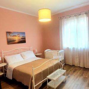 a bedroom with a white bed and a window at La Casa di Andreina in Mondello
