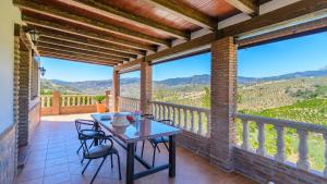 d'une terrasse avec une table et des chaises sur un balcon. dans l'établissement Casa Los Valles Alozaina by Ruralidays, à Alozaina