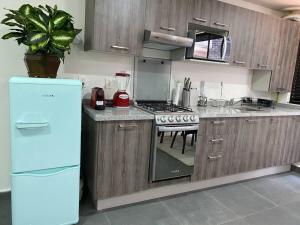 a kitchen with a refrigerator and a stove top oven at NUEVO y ubicado departamento ZONA SANTAFE in Mexico City