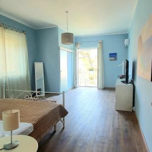 a bedroom with blue walls and a bed and a television at La Casa di Andreina in Mondello