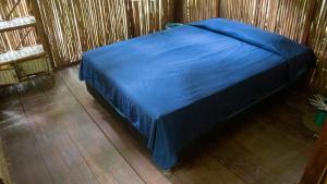 a blue bed in a room with a wooden floor at La Playita in Guachaca +53 photos