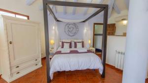 a bedroom with a canopy bed with white sheets and pillows at Casa El Paraiso Escondido Montecorto by Ruralidays in Montecorto