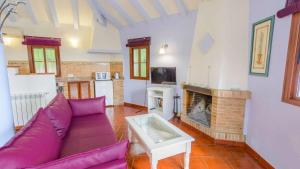 a living room with a purple couch and a fireplace at Casa El Paraiso Escondido Montecorto by Ruralidays in Montecorto