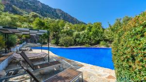 a pool with a table and chairs and a umbrella at Casa El Paraiso Escondido Montecorto by Ruralidays in Montecorto
