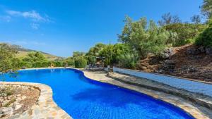 a swimming pool with blue water in a yard at Casa El Paraiso Escondido Montecorto by Ruralidays in Montecorto