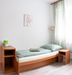 Cama en habitación con mesa y ventana en Ubytovanie SASINKOVA en Žilina