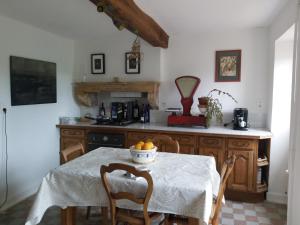 een keuken met een tafel met stoelen en een fornuis bij Gite du jardin du Bout du Ciel in Céron