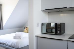 a microwave sitting on a counter next to a bed at Bright & Beautiful Studio Flat in Bristol! in Bristol
