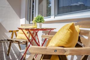 einen Tisch und einen Stuhl mit einer Pflanze auf dem Balkon in der Unterkunft Murányi Vendégház in Mórahalom