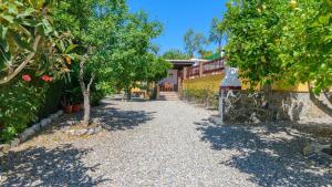 eine Kieseinfahrt mit Bäumen und einem Gebäude in der Unterkunft Casa La Recacha Orgiva by Ruralidays in Órgiva