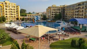 a large pool with tables and umbrellas in a resort at Midia Grand Resort, Terrassen Paradies Apartment in Aheloy