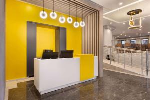 una oficina con paredes amarillas y una recepción blanca en Days Hotel by Wyndham Ankara Cankaya en Ankara