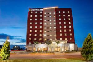 a hotel with a tall building in the evening at Hyatt Place Aguascalientes Bonaterra in Aguascalientes